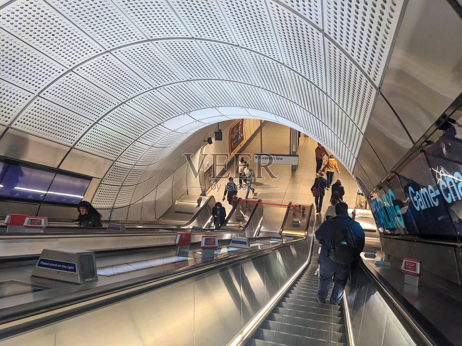 乘客们在现代化的伦敦地铁站乘坐伊丽莎白线自动扶梯下行照片摄影图片