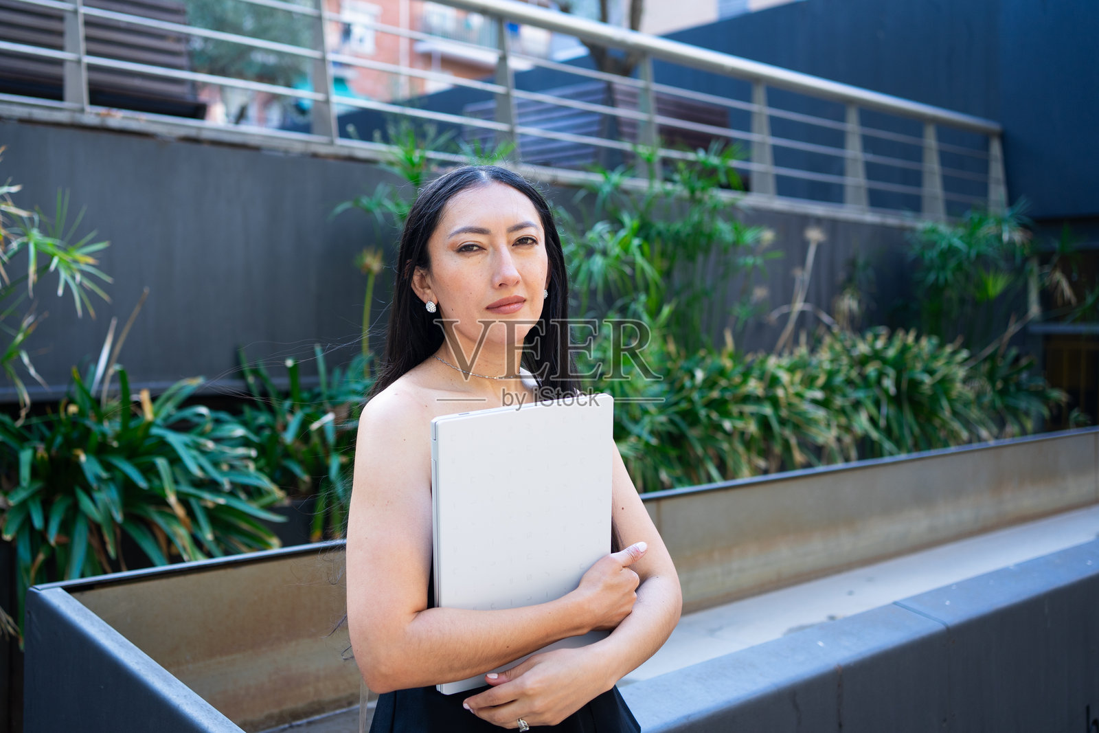 职业女性在城市背景下使用笔记本电脑照片摄影图片