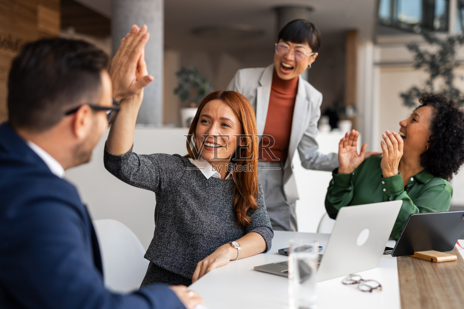 同事们在现代办公环境中击掌庆祝成功照片摄影图片