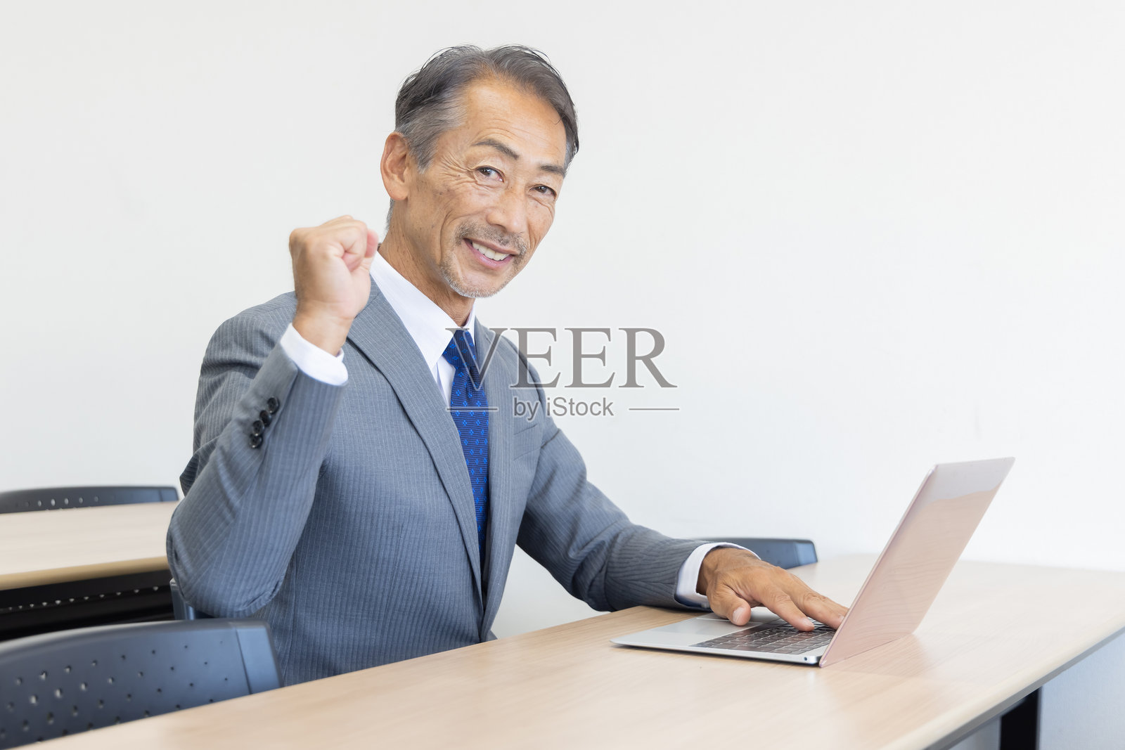 一位年长的商人正在使用笔记本电脑照片摄影图片