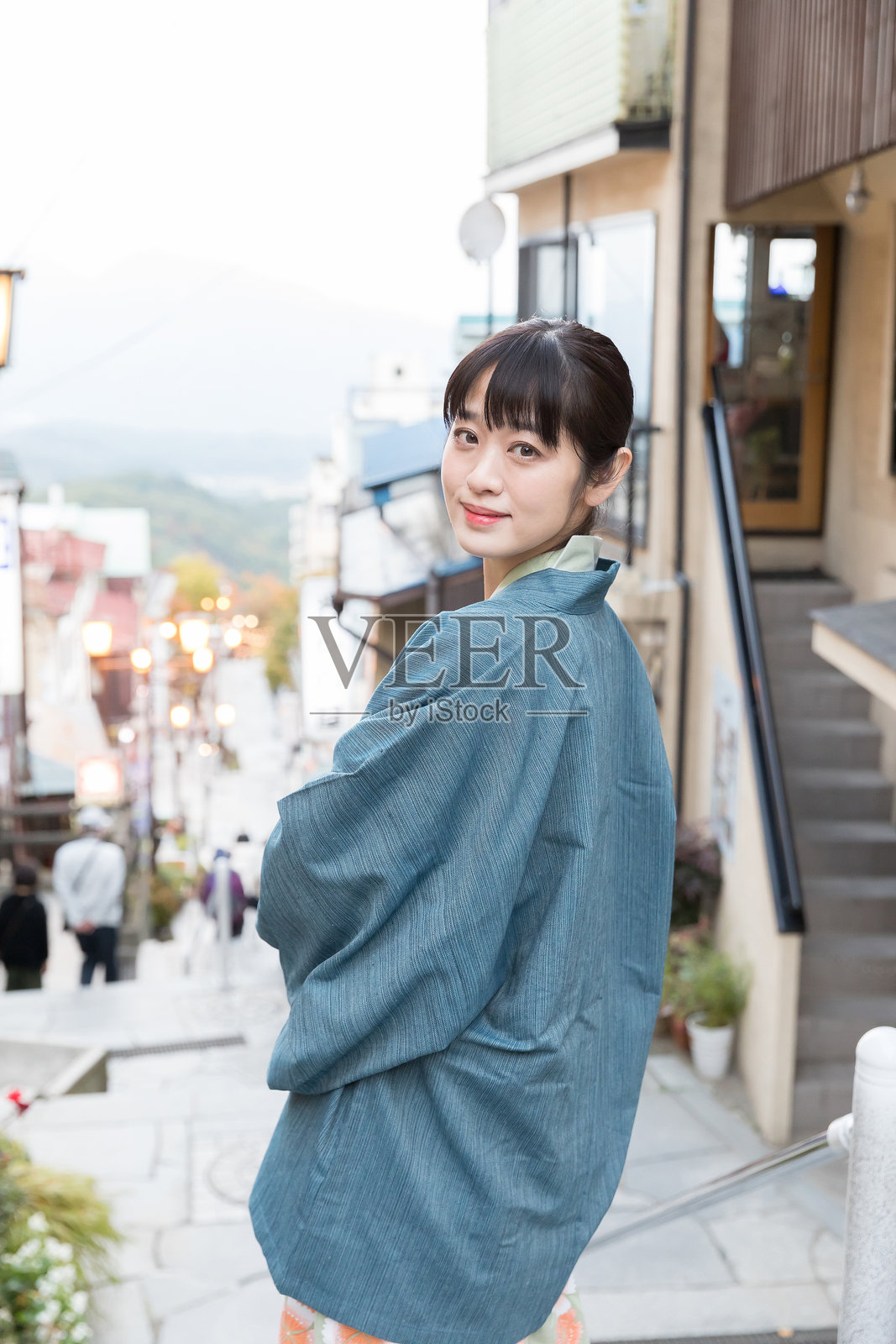 一位女士漫步在温泉小镇照片摄影图片