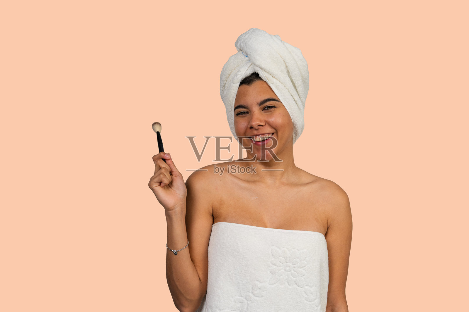 淋浴后，一位女子微笑着拿着化妆刷照片摄影图片