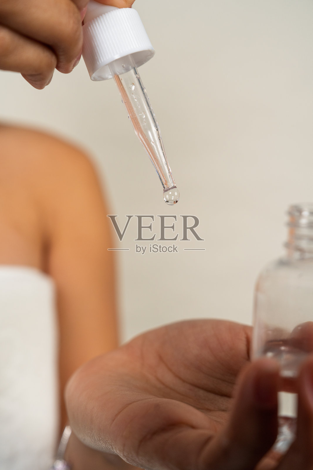 女性在手部涂抹护肤精华，进行美容日常照片摄影图片