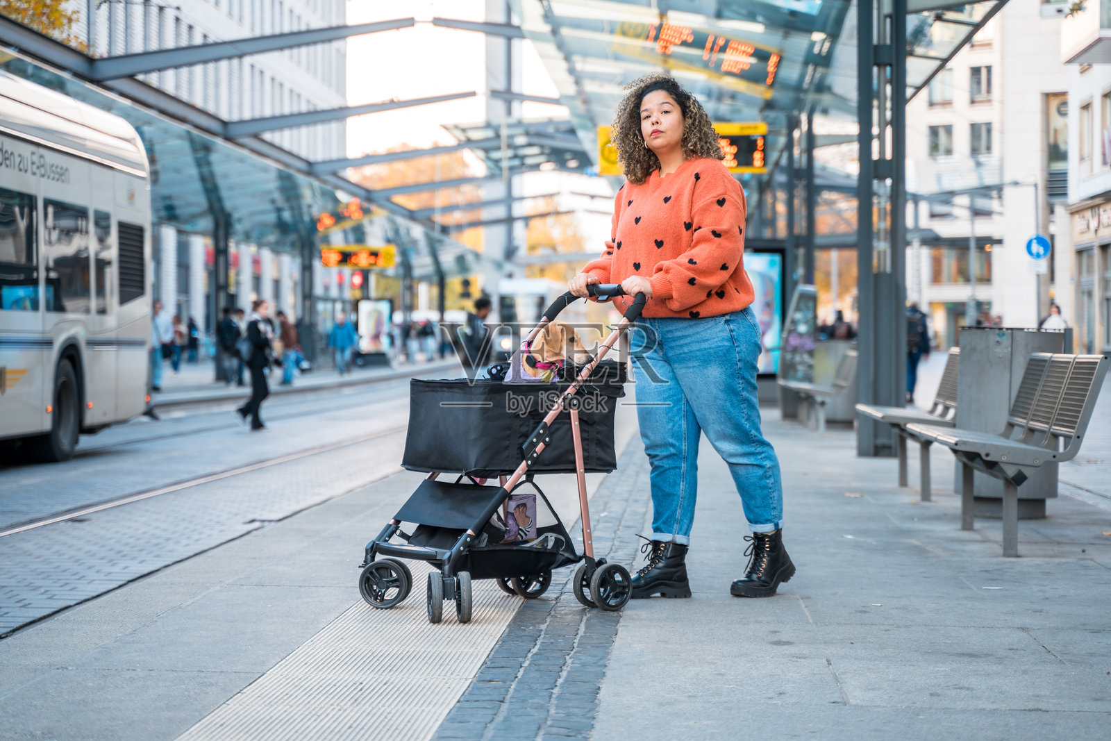 一位巴西女性在德累斯顿推着宠物狗坐在婴儿车里照片摄影图片