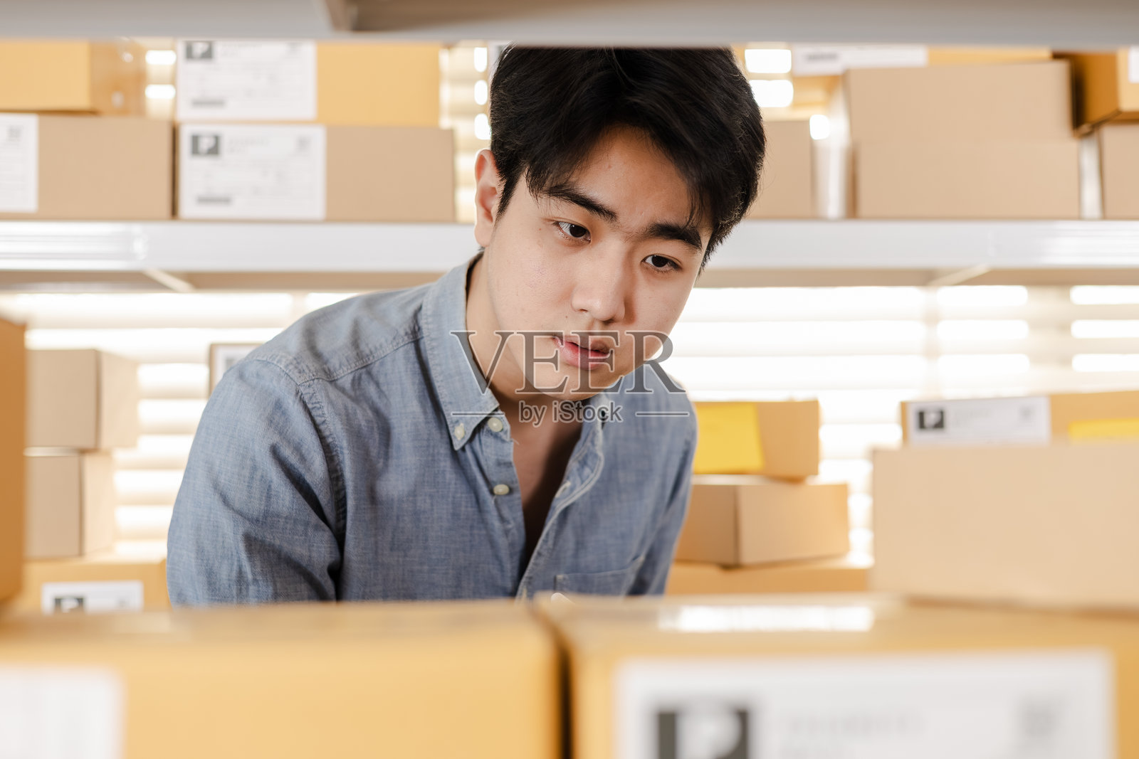 小型企业仓库员工使用平板电脑技术进行库存检查和工作，支持准确的库存更新、包裹整理、订单控制以及现代化仓库中的高效电子商务发货。照片摄影图片