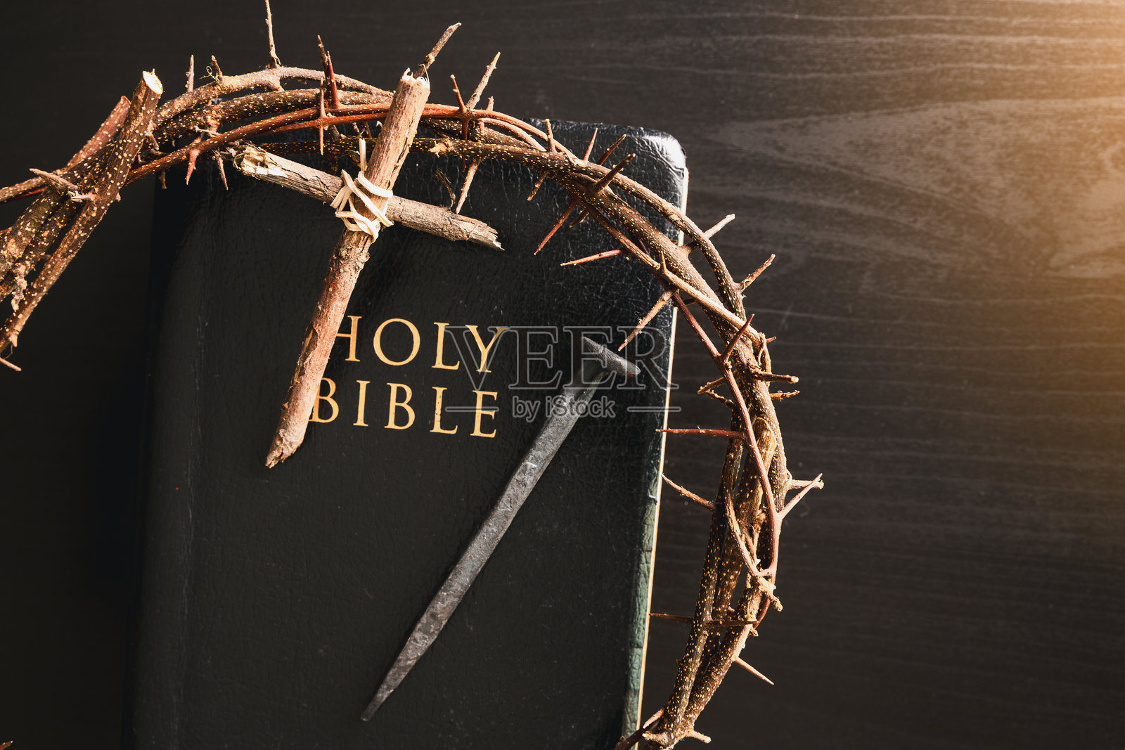 荆棘冠冕、木制十字架、铁钉放在圣经上，象征着基督教信仰、牺牲、受难、复活节反思、崇拜的宗教背景、精神概念照片摄影图片