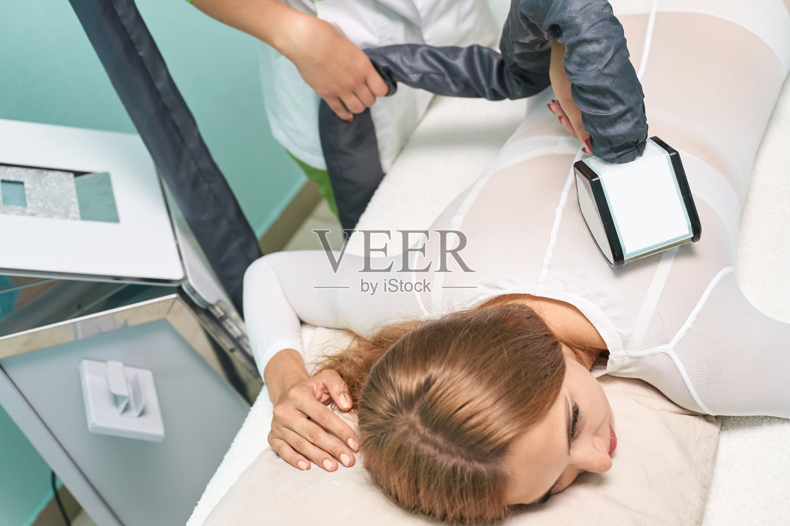 女性在美容院接受冷冻疗法，技师正在使用冷冻设备照片摄影图片