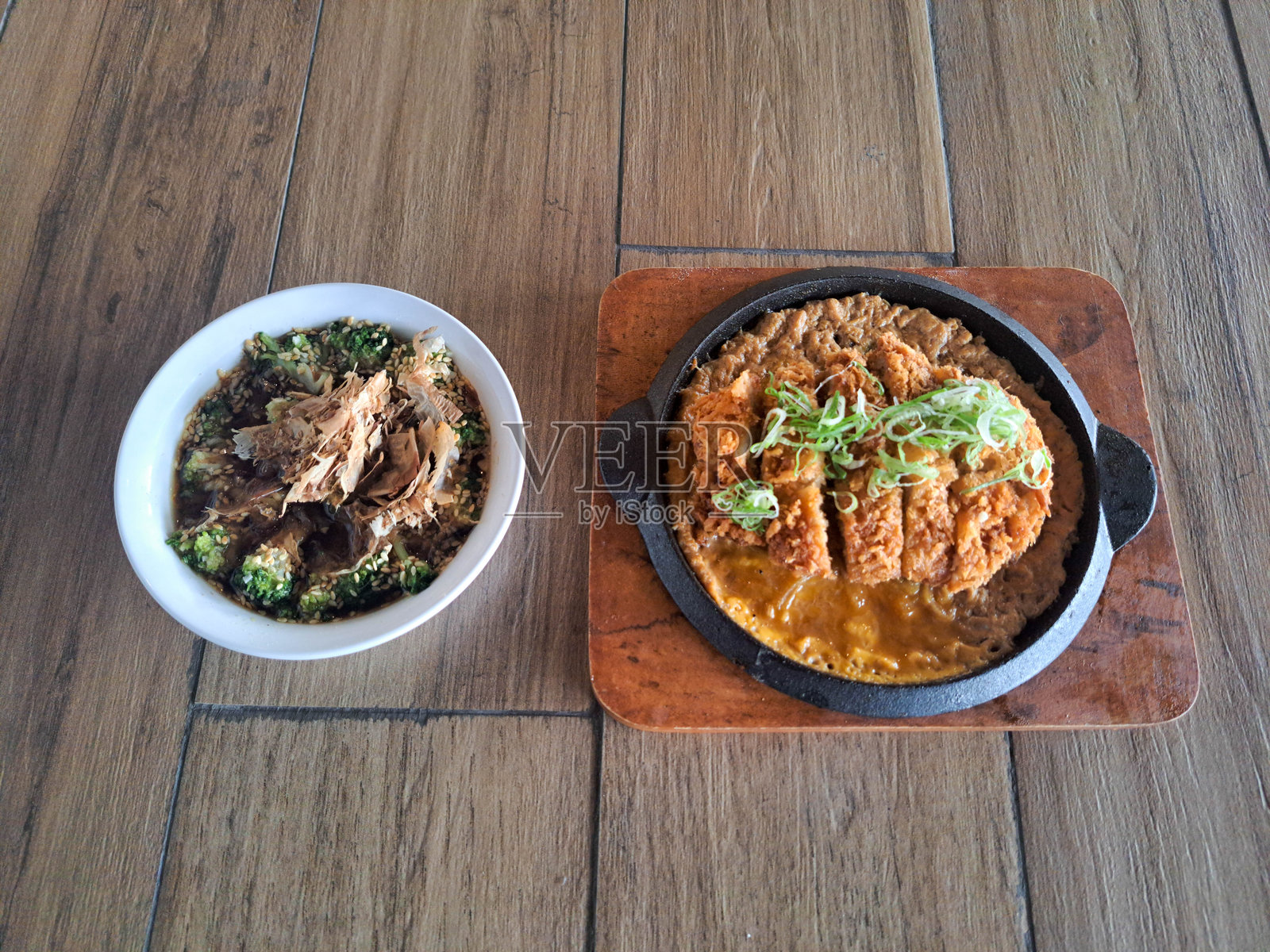 西兰花浸拌菜或炒西兰花，佐以鲜味高汤酱汁和鲣鱼片。炸猪排饭配千层炸猪排、丼酱、洋葱和鸡蛋。菜单。照片摄影图片