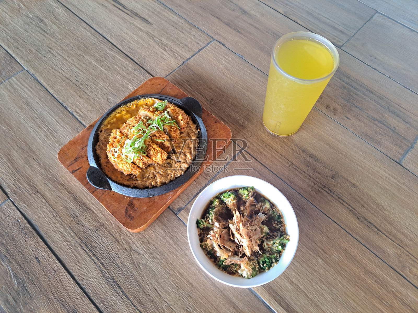 西兰花煮浸或炒西兰花，淋上鲜美的日式高汤酱汁，撒上海苔碎或鲣鱼干。炸猪排饭配千层炸猪排、丼饭酱汁、洋葱和鸡蛋。搭配冷茶绿茶。菜单。照片摄影图片