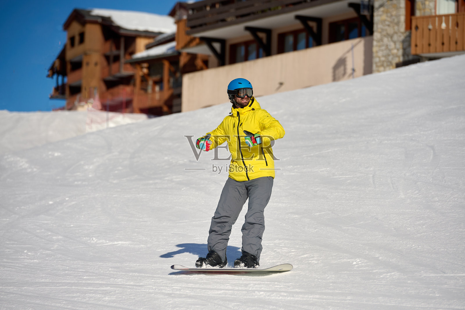 滑雪胜地，滑雪者在阿尔卑斯风格的小屋附近滑行照片摄影图片