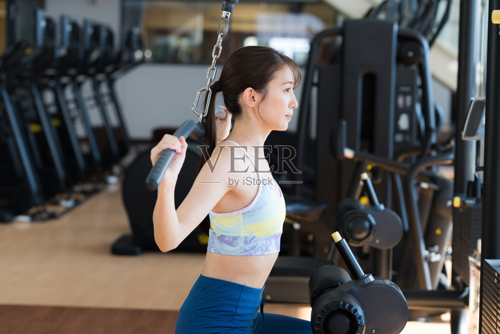 年轻女子在健身房锻炼照片摄影图片