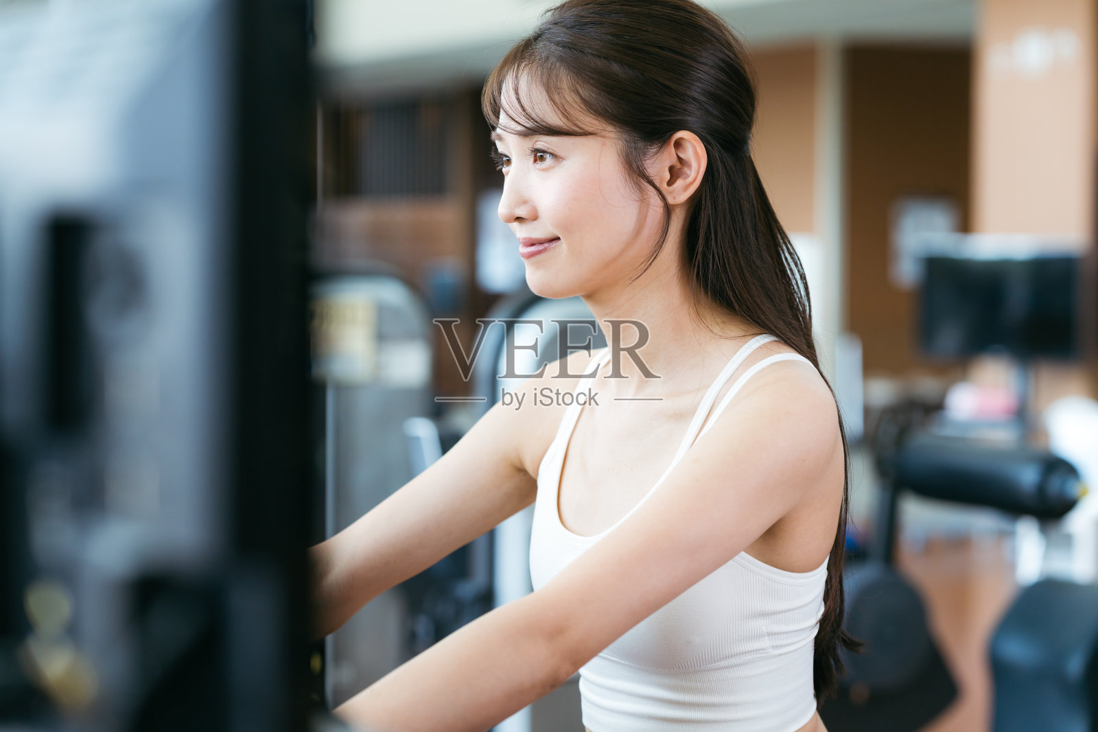 年轻女子在健身房训练照片摄影图片