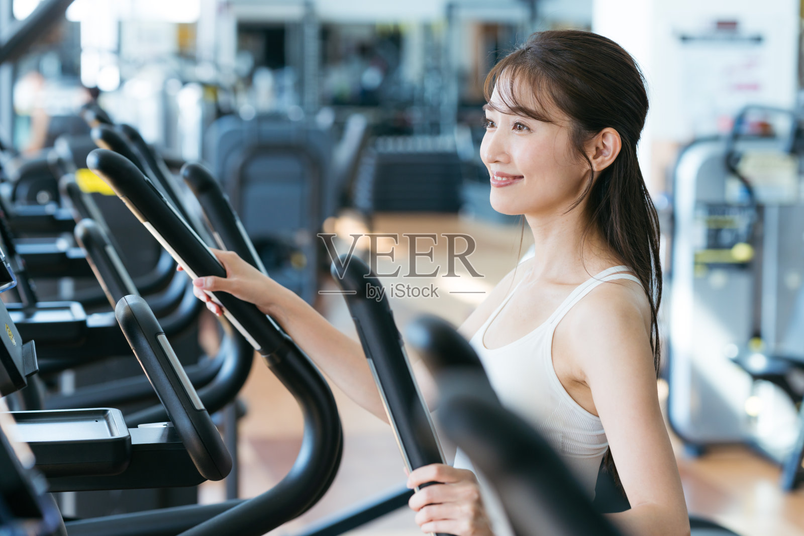 年轻女子在健身房训练照片摄影图片