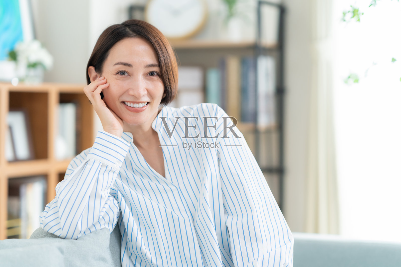 中年女子在客厅里看智能手机照片摄影图片