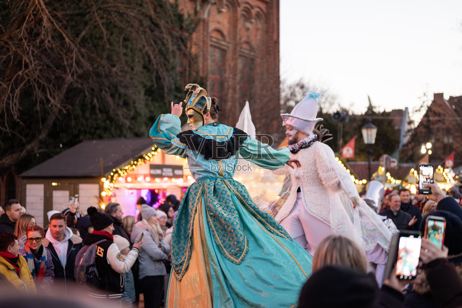 圣诞集市上的音乐会，演员们扮演着滑稽的小丑照片摄影图片
