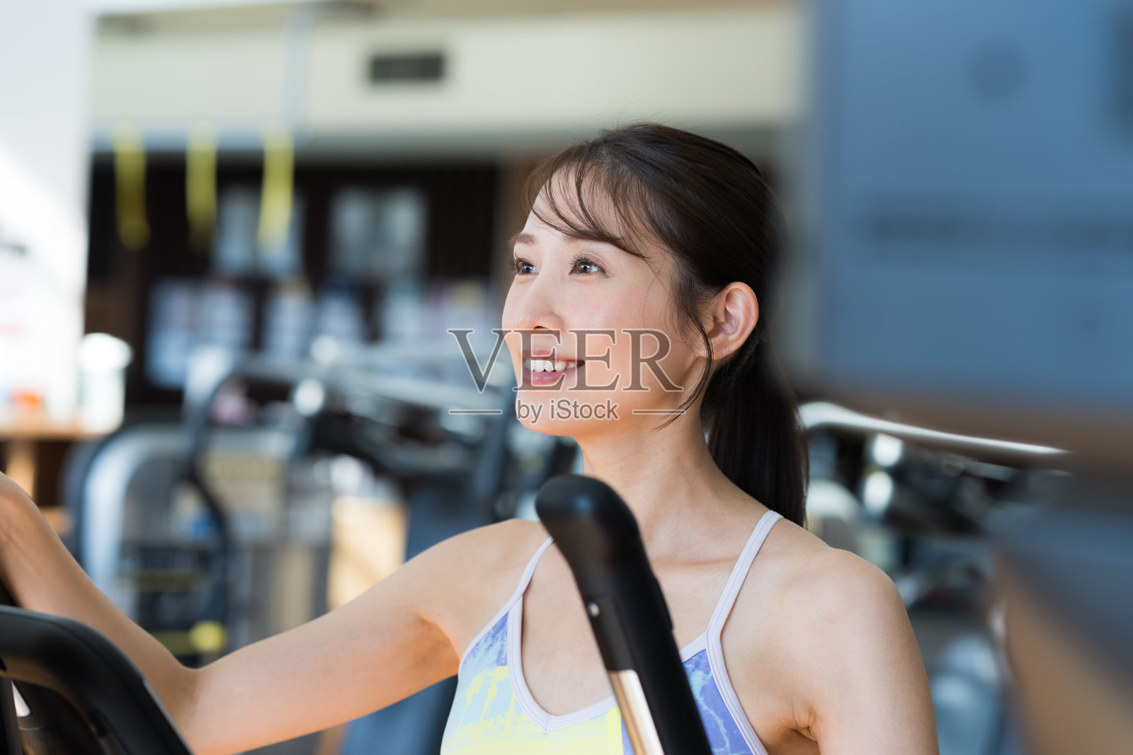 年轻女子在健身房锻炼照片摄影图片