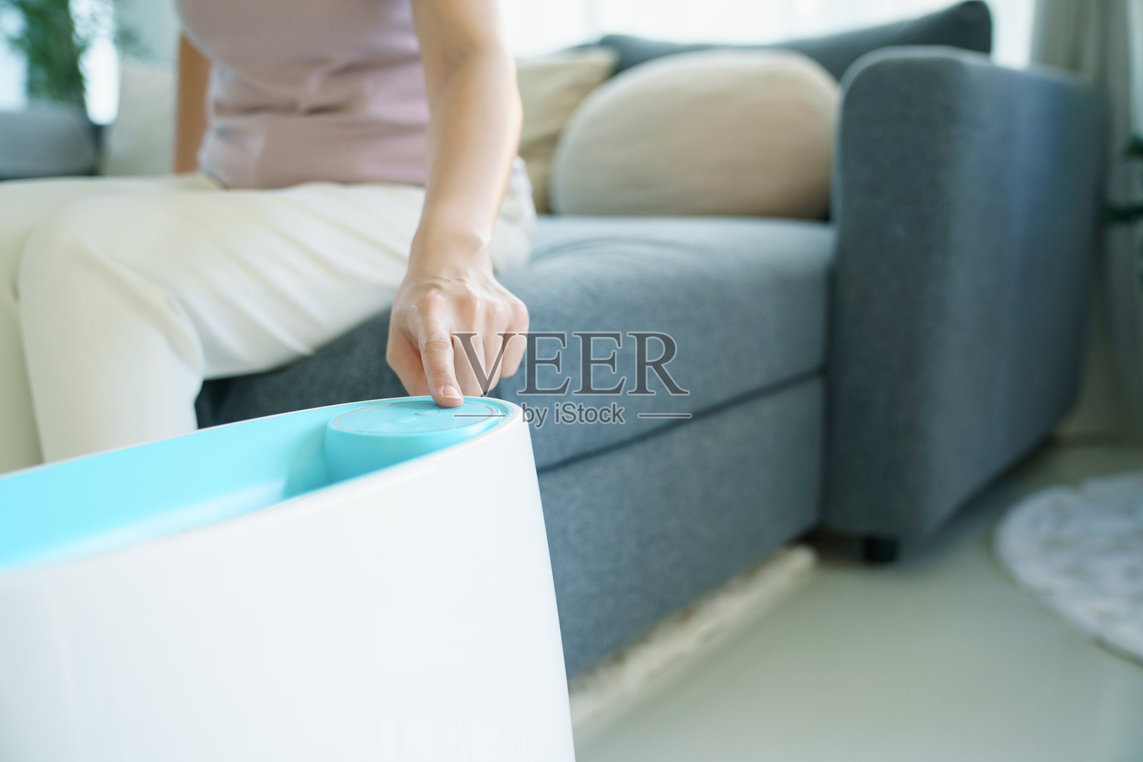 女士在客厅使用家用空气净化器或加湿器照片摄影图片