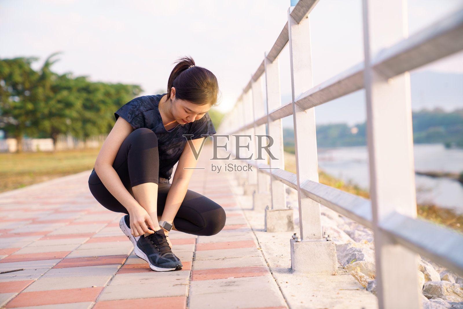 亚洲女性在河边户外锻炼前系跑鞋照片摄影图片