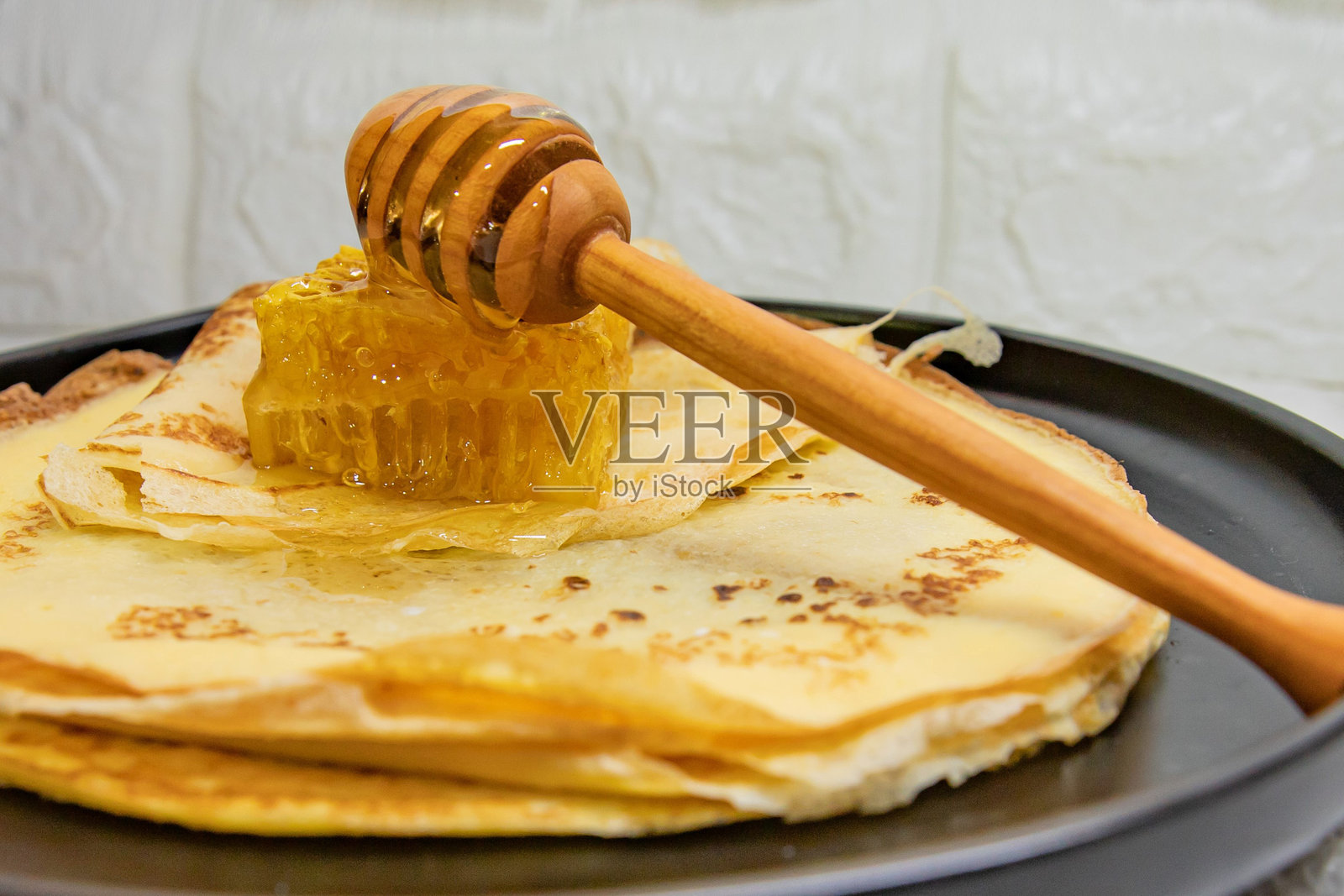 自制煎饼淋上天然蜂蜜和蜂巢，营造温馨的早餐概念照片摄影图片