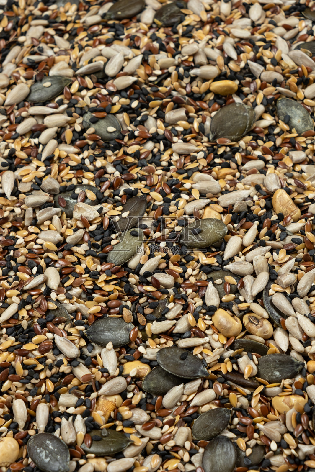 混合了葵花籽、南瓜籽、亚麻籽、芝麻和黄豆等健康超级食物种子。照片摄影图片