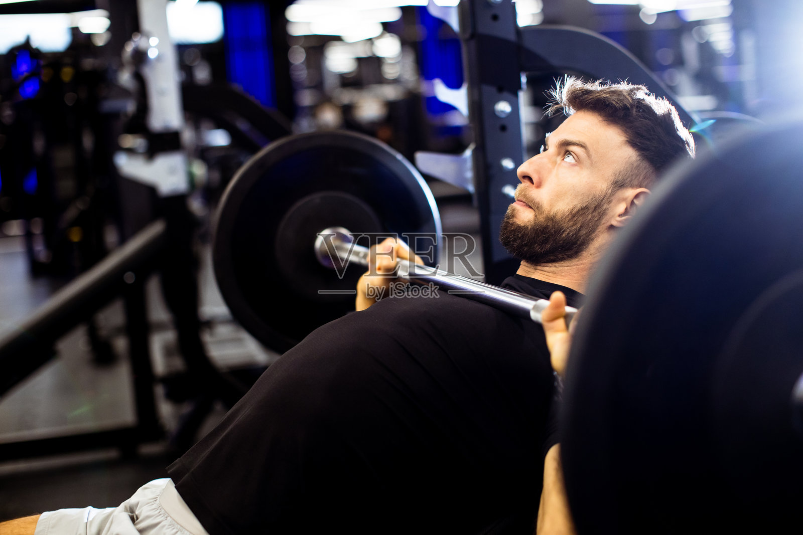 在现代健身房进行举重训练，注重力量训练和健身照片摄影图片