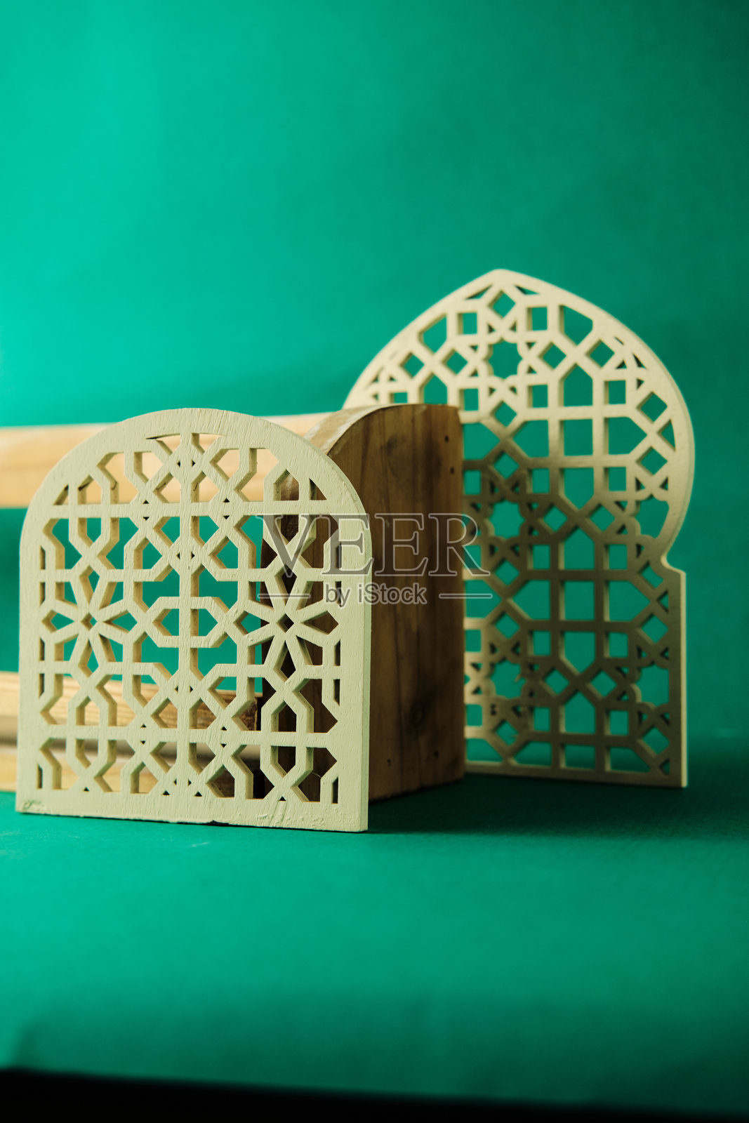 绿色背景上的激光切割木制斋月灯笼和阿拉伯风格装饰拱门照片摄影图片