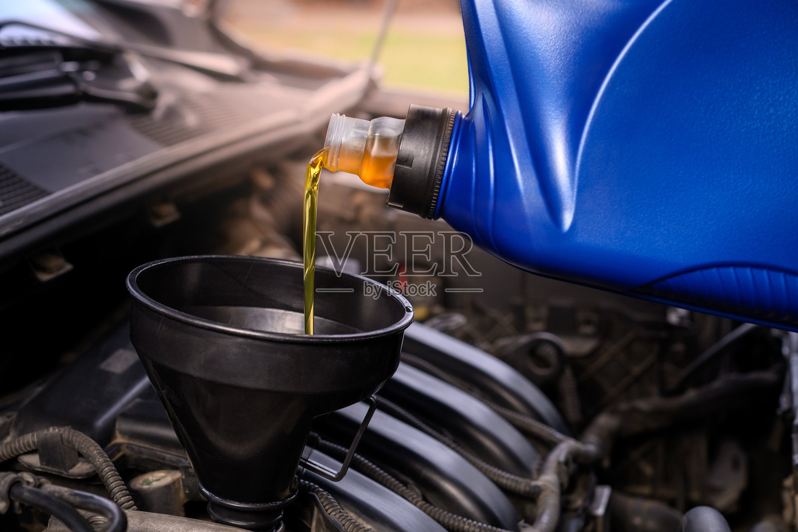 向汽车发动机中倒油照片摄影图片