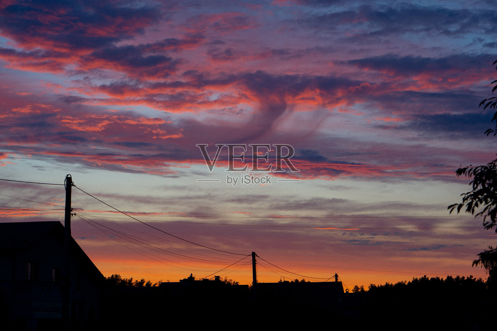 城市边缘建筑旁美丽的渐变日落，有紫色、黄色、蓝色和红色的云彩照片摄影图片