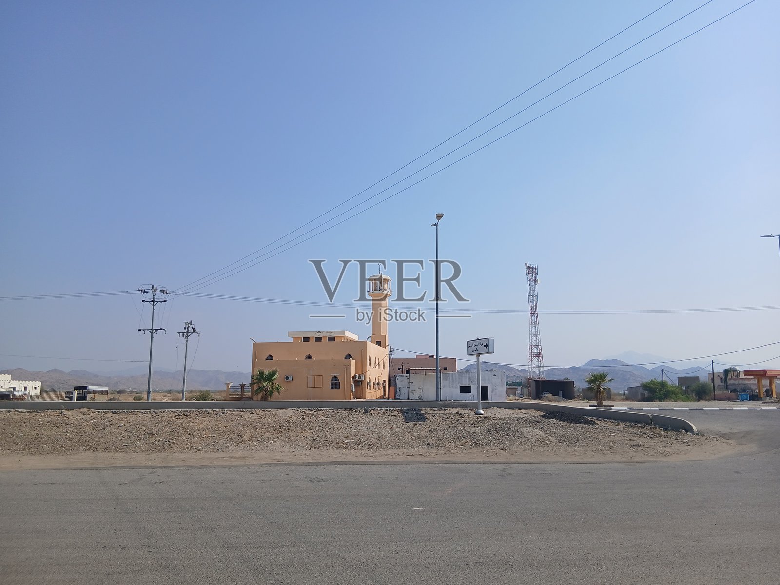 Al-Baha,Al-Jareen镇主街上的清真寺、通信塔和电力灯杆照片摄影图片