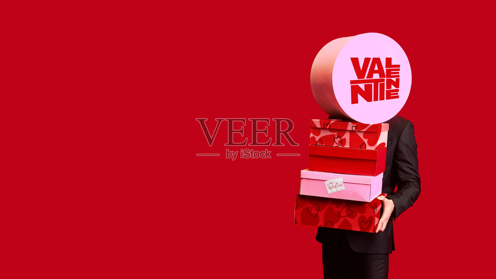 背景为红色的粗犷艺术作品，一个人拿着大礼盒。照片摄影图片