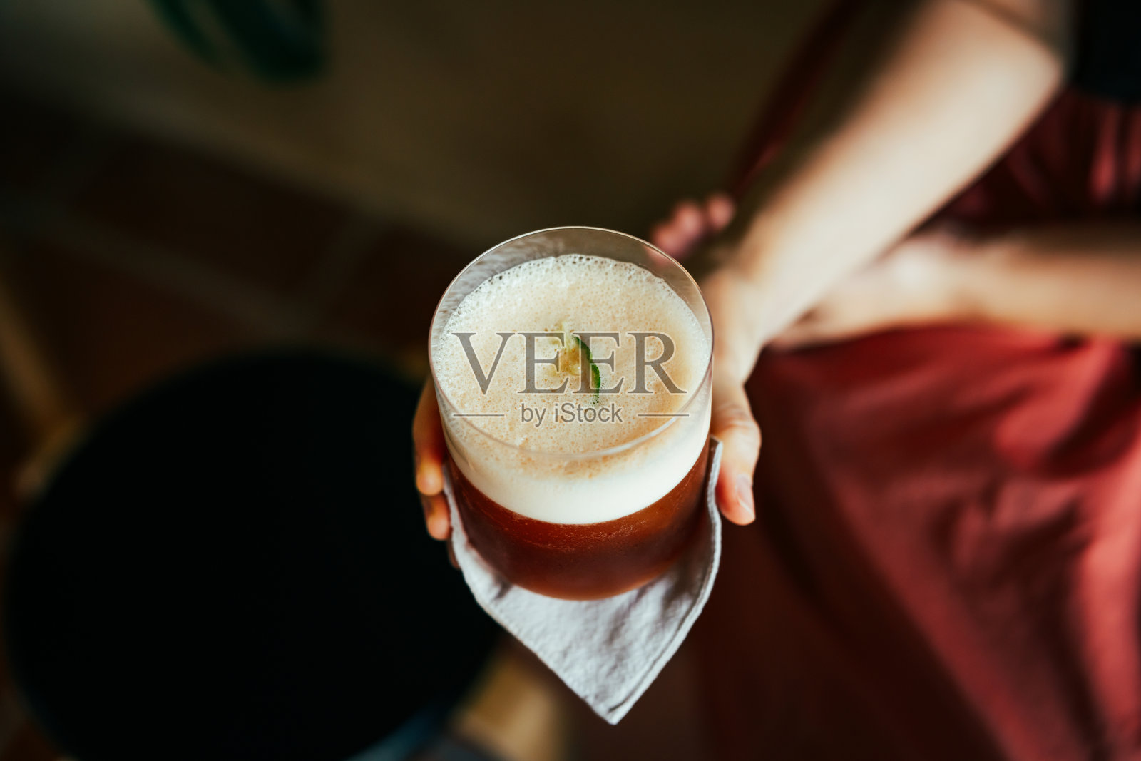 一位女士正拿着一杯冷萃咖啡。照片摄影图片