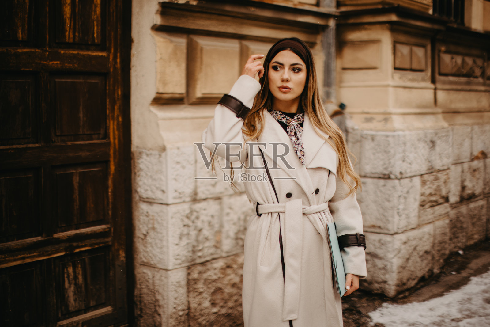 穿着风衣的年轻女性在城市背景下照片摄影图片