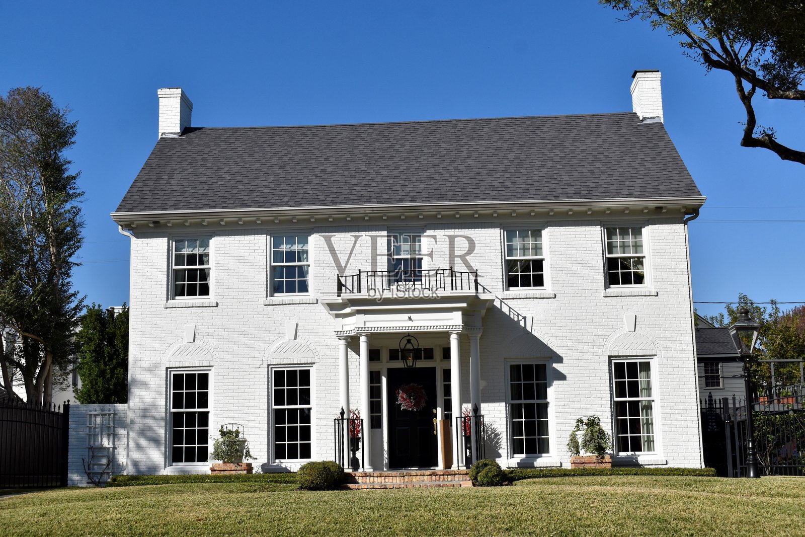 一座位于高档社区的豪华复古风格豪宅,拥有优雅的建筑、精心打理的景观和永恒的高档设计。照片摄影图片