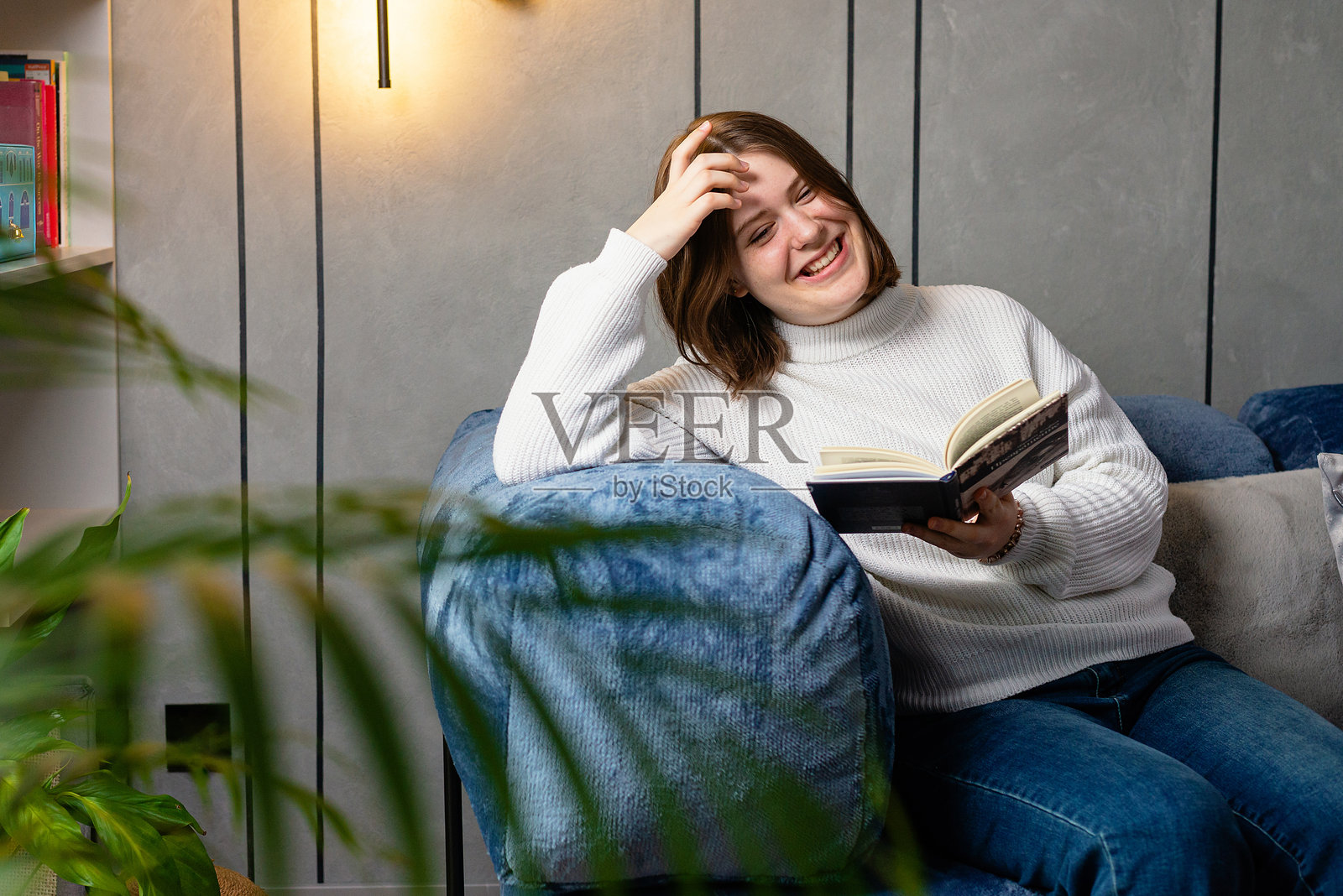 舒适冬季生活方式：女子在家沙发上读书照片摄影图片