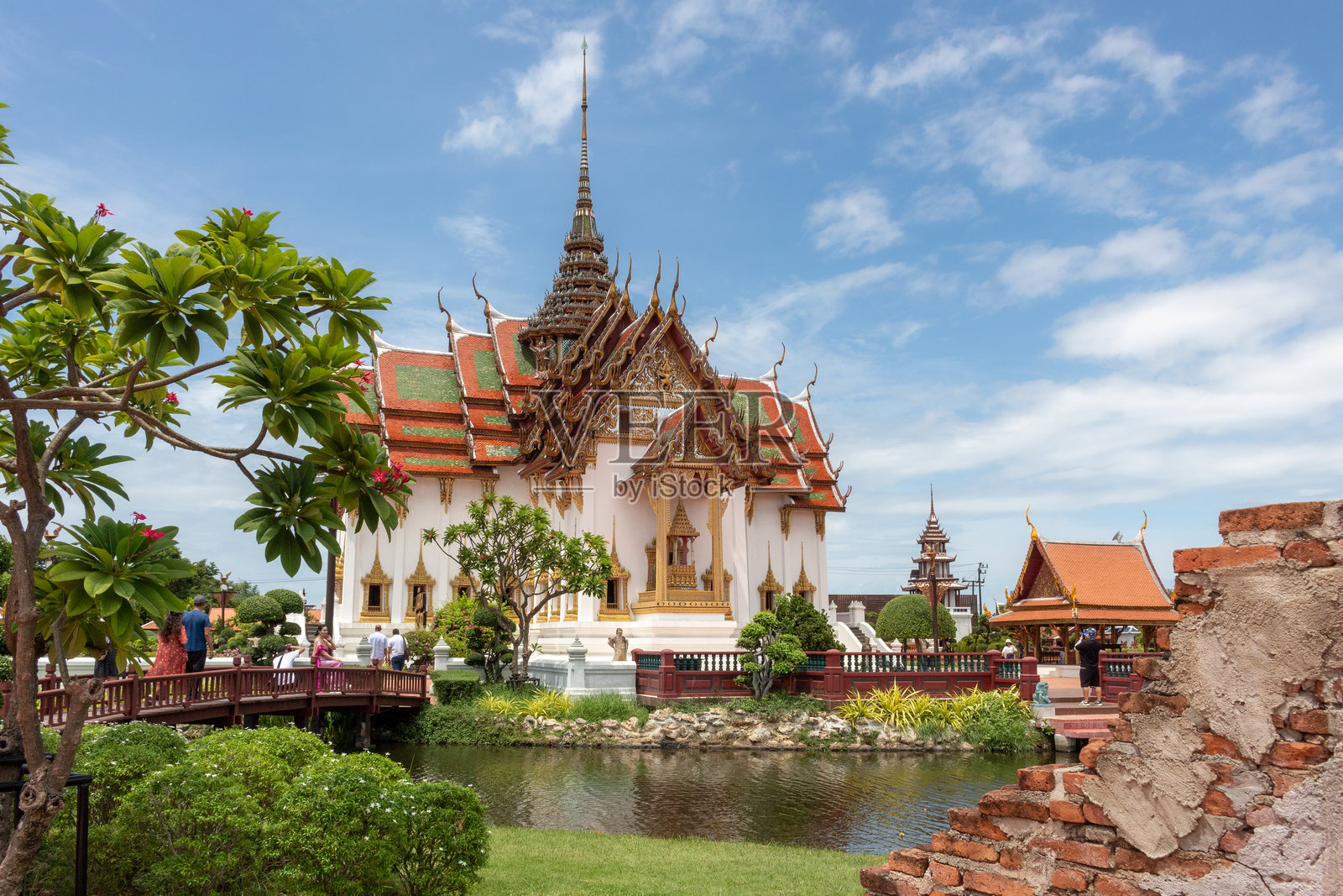 古代城市水塘上，宏伟的杜西特玛哈普拉萨宫宝塔寺庙建筑外部的丰富多彩的精细建筑照片摄影图片