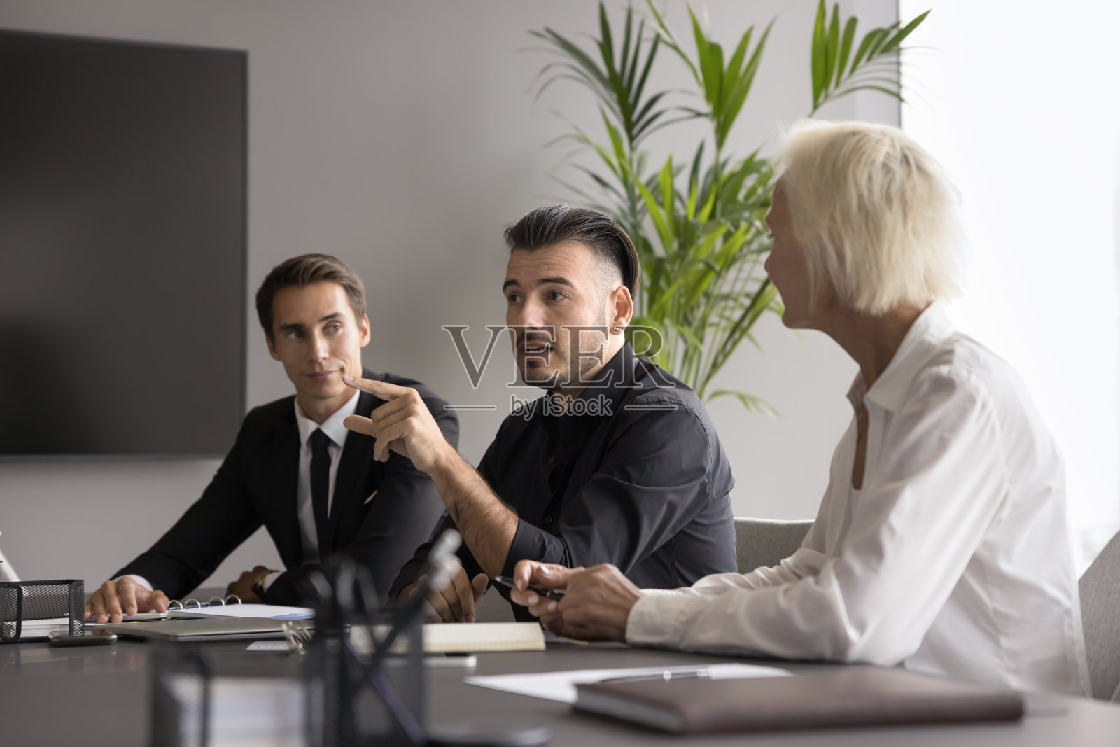 年轻的男性团队领导向员工解释项目细节照片摄影图片