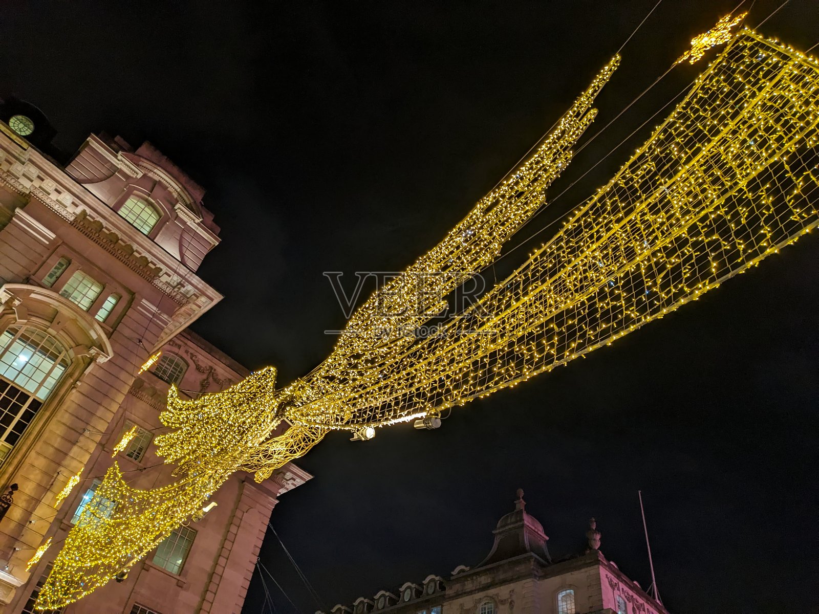 仰视拍摄的著名圣诞天使灯照亮伦敦摄政街照片摄影图片