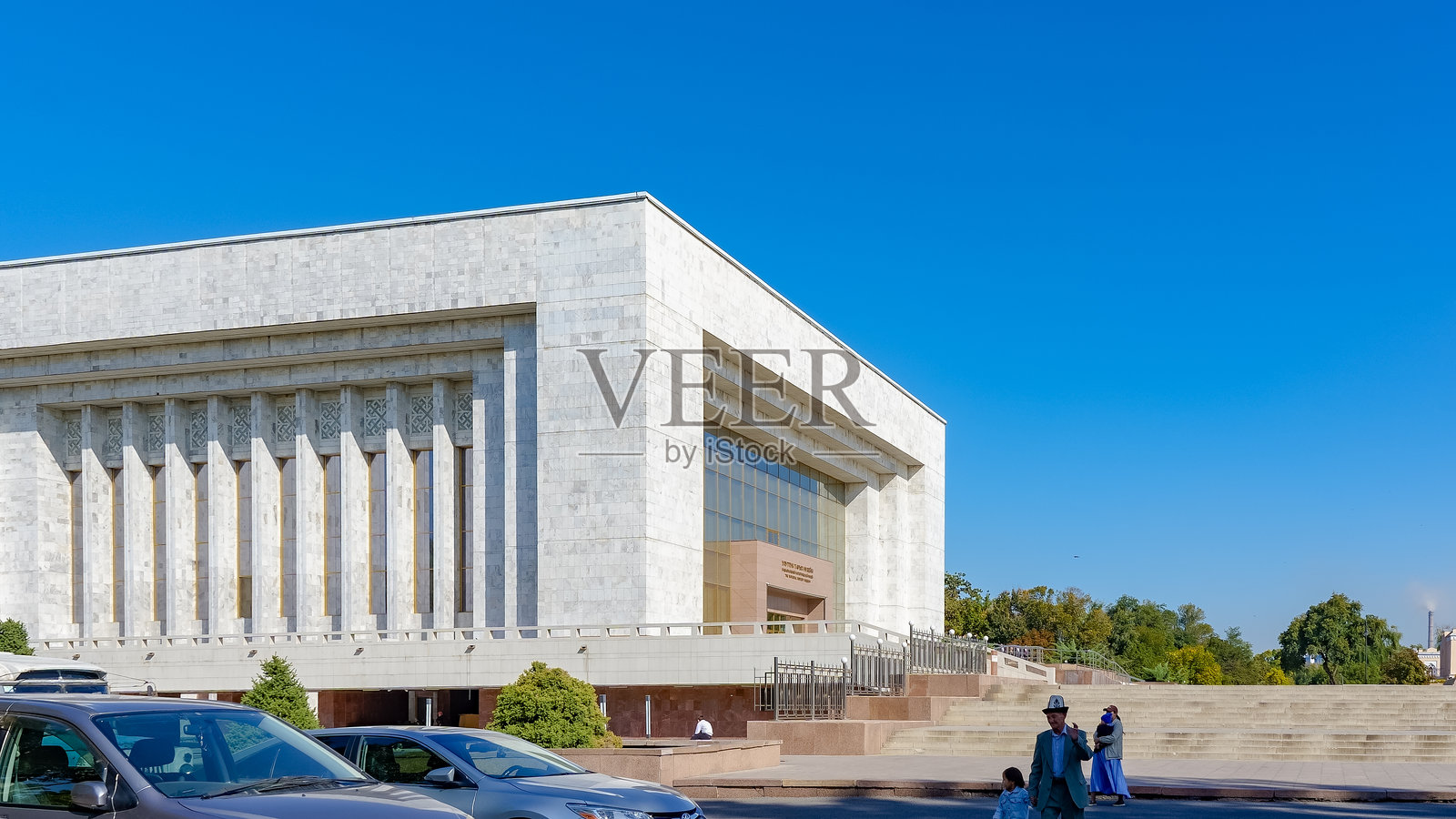 吉尔吉斯斯坦阿拉套广场国家历史博物馆，展示了现代建筑和充满活力的周边环境，天空湛蓝。照片摄影图片