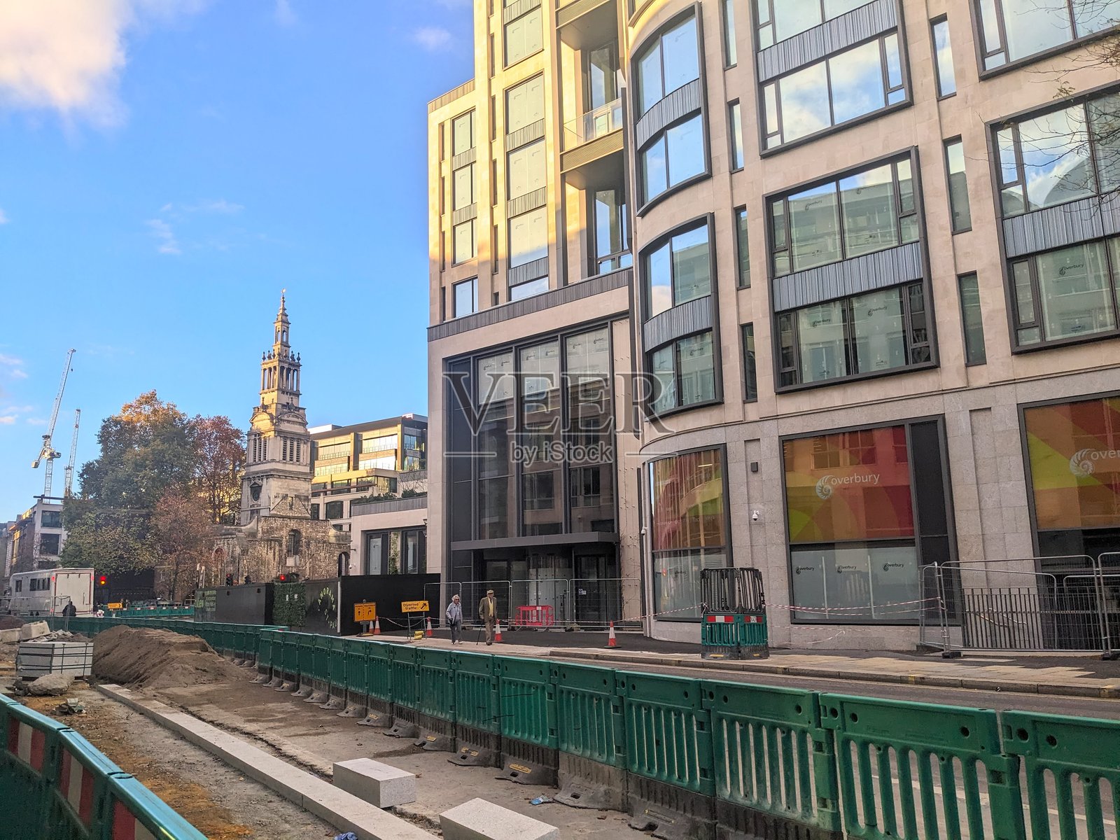 伦敦建筑的对比：基督教堂灰衣修士塔旁边的现代建筑和道路工程照片摄影图片