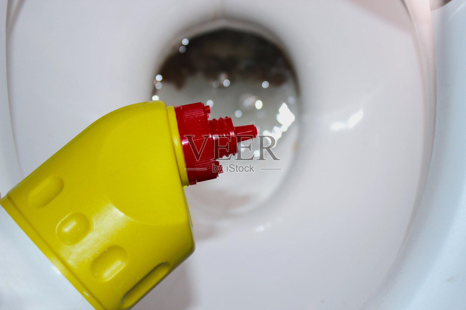 黄色马桶清洁凝胶瓶放在陶瓷马桶上照片摄影图片