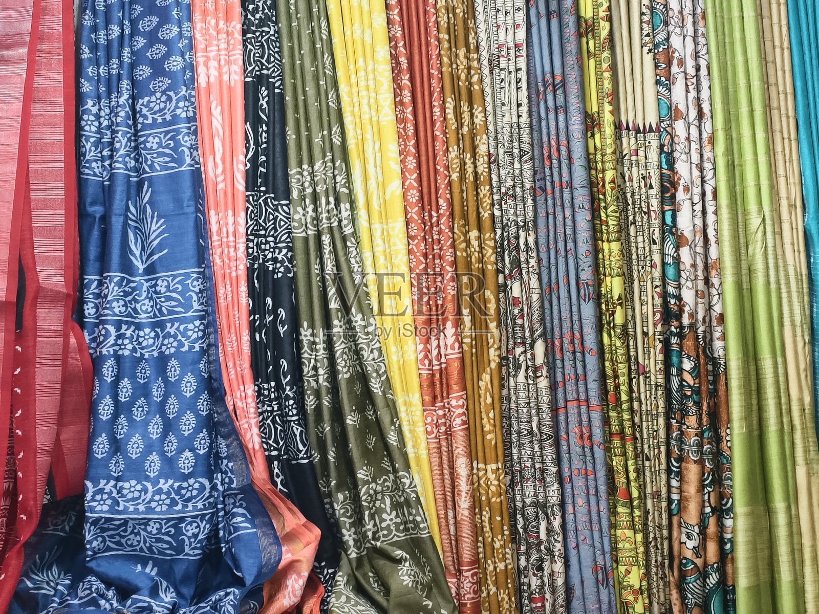 特写镜头，展示零售店里堆叠的纱丽，用作印度纺织品背景。照片摄影图片