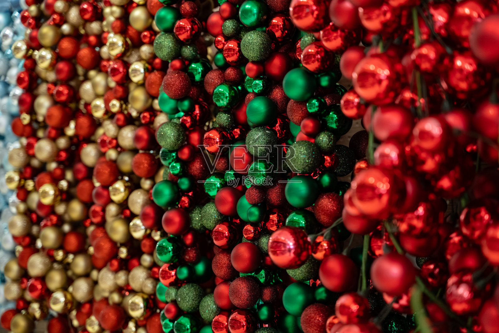 特写镜头下色彩斑斓的圣诞装饰品，包含红色、绿色和金色的彩球。照片摄影图片