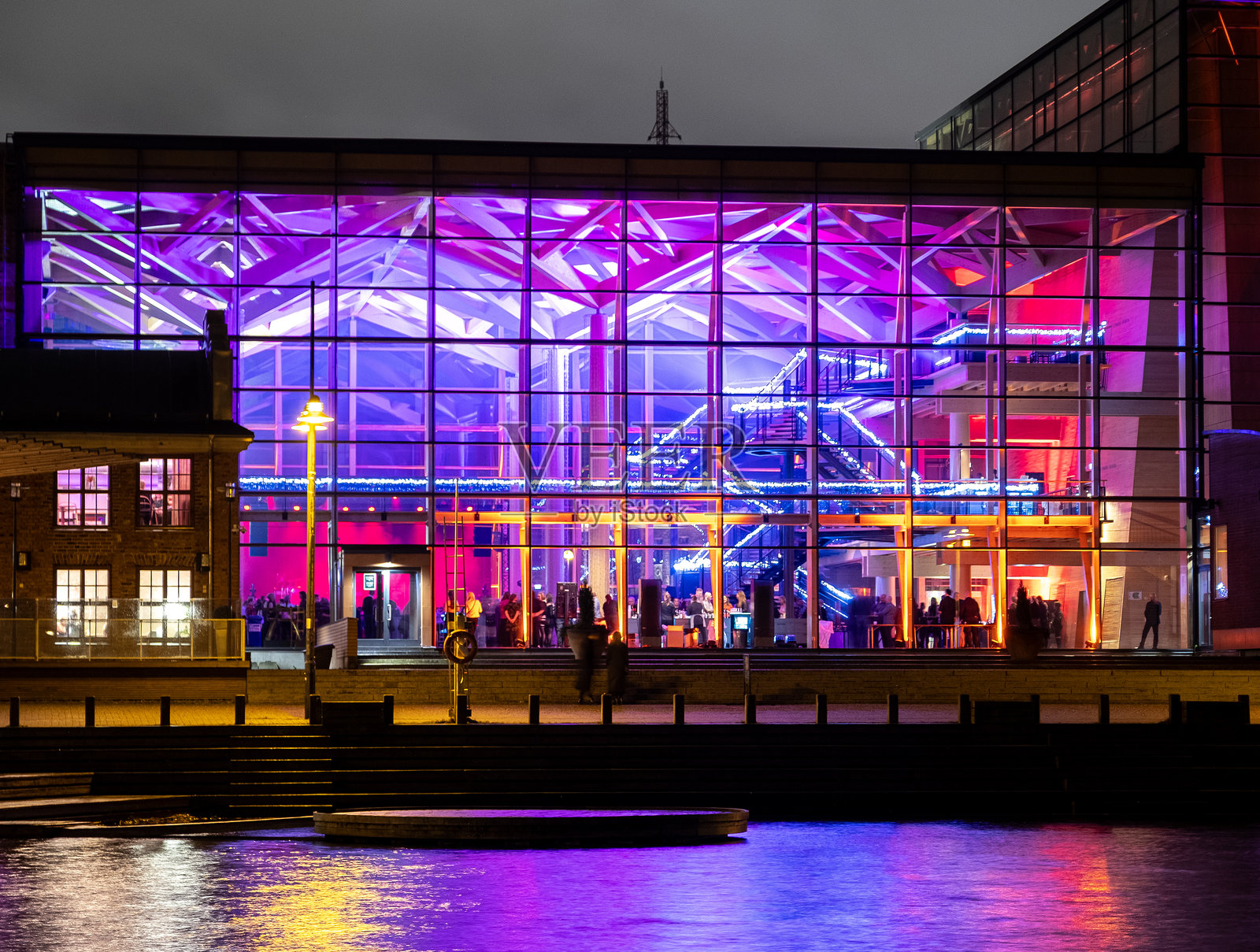 傍晚时分,维埃里西斯湖畔的西贝柳斯音乐厅亮起了彩色灯光。照片摄影图片