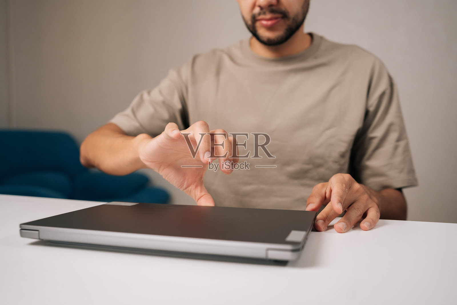 特写：留着胡子的商人正在打开笔记本电脑，准备在家办公，在成功远程工作一天后感到满意和高效。照片摄影图片