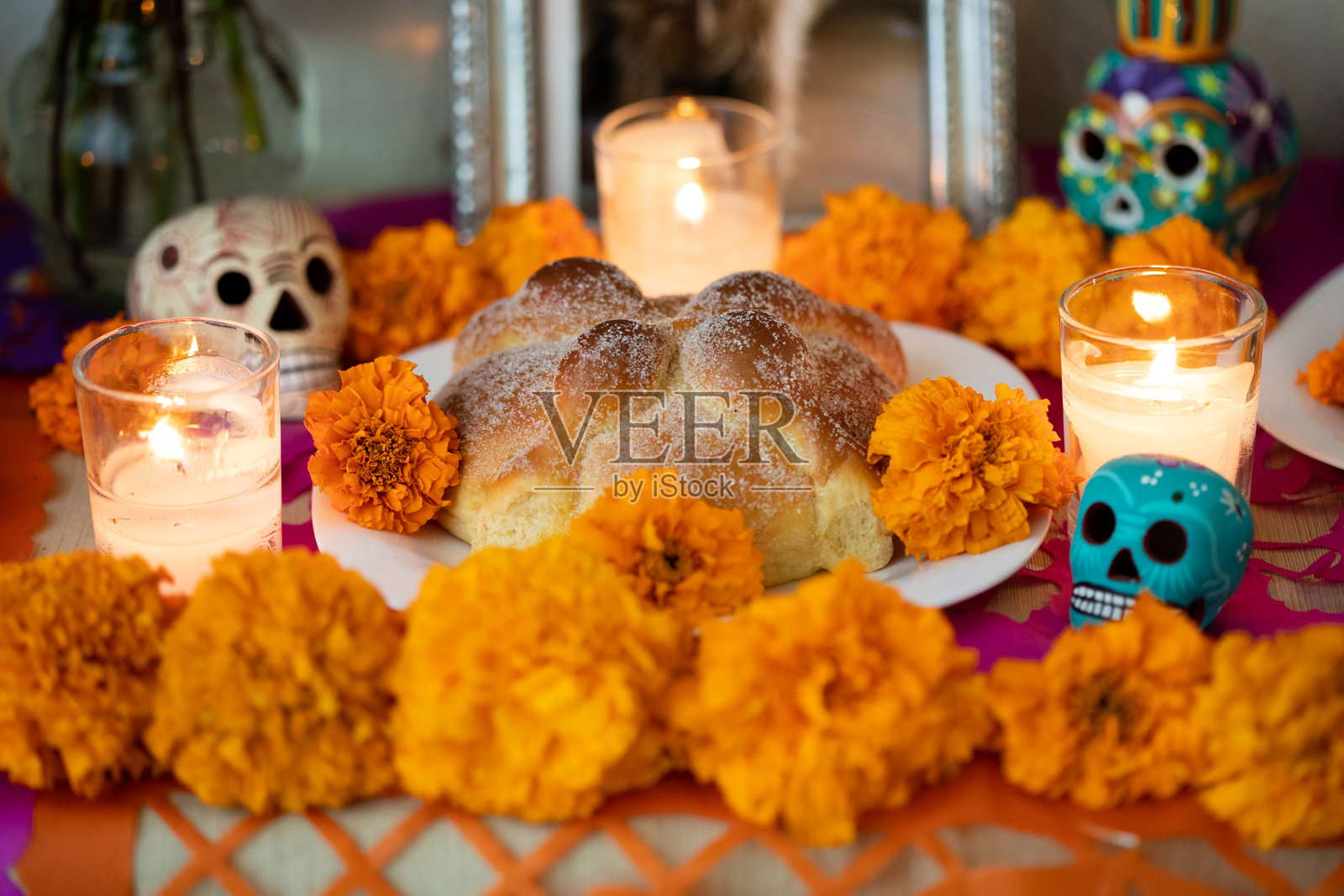 亡灵节祭坛，上面摆放着墨西哥亡灵节面包、万寿菊、蜡烛、彩纸和陶瓷骷髅照片摄影图片