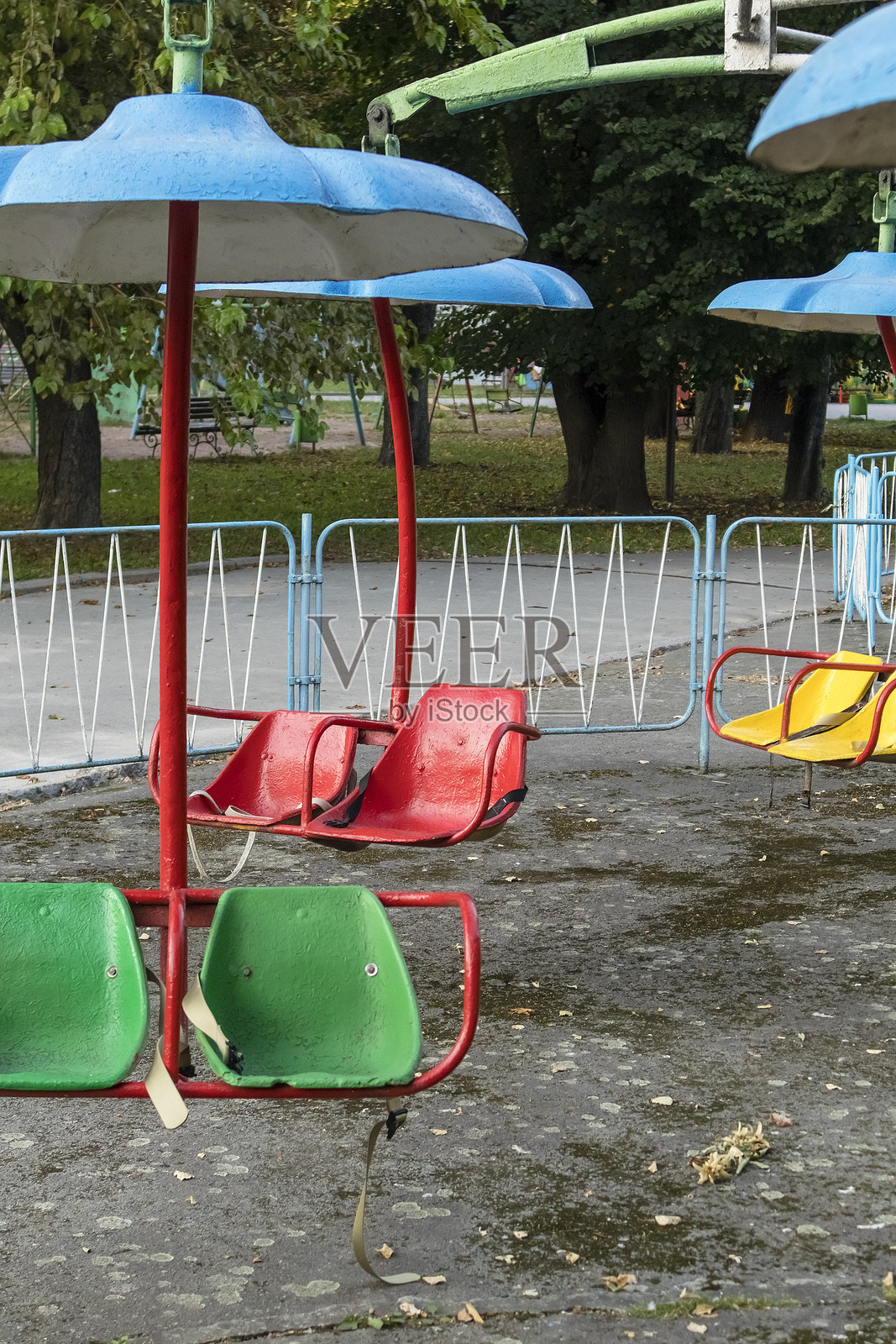 一个色彩缤纷的复古游乐场旋转木马，静静地伫立在宁静的城市公园里，勾起童年的怀旧情怀和对户外悠闲时光的向往。照片摄影图片