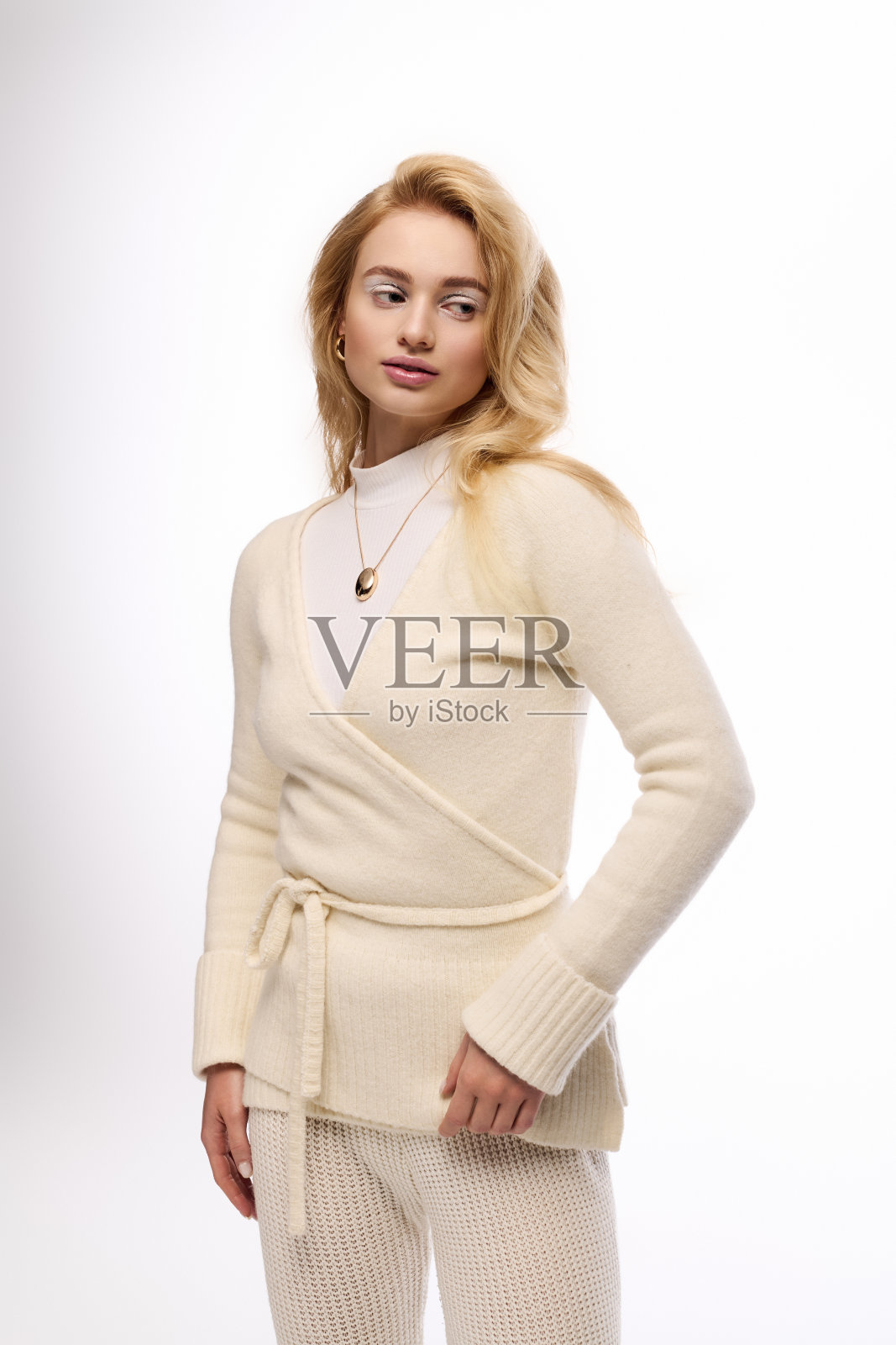 年轻的金发女子身着针织舒适服饰，展现冬日优雅照片摄影图片