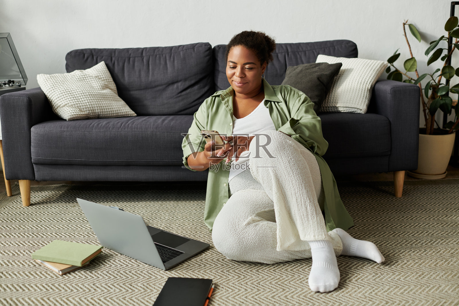 一位女士在现代公寓中放松，室内享受科技带来的便利生活照片摄影图片