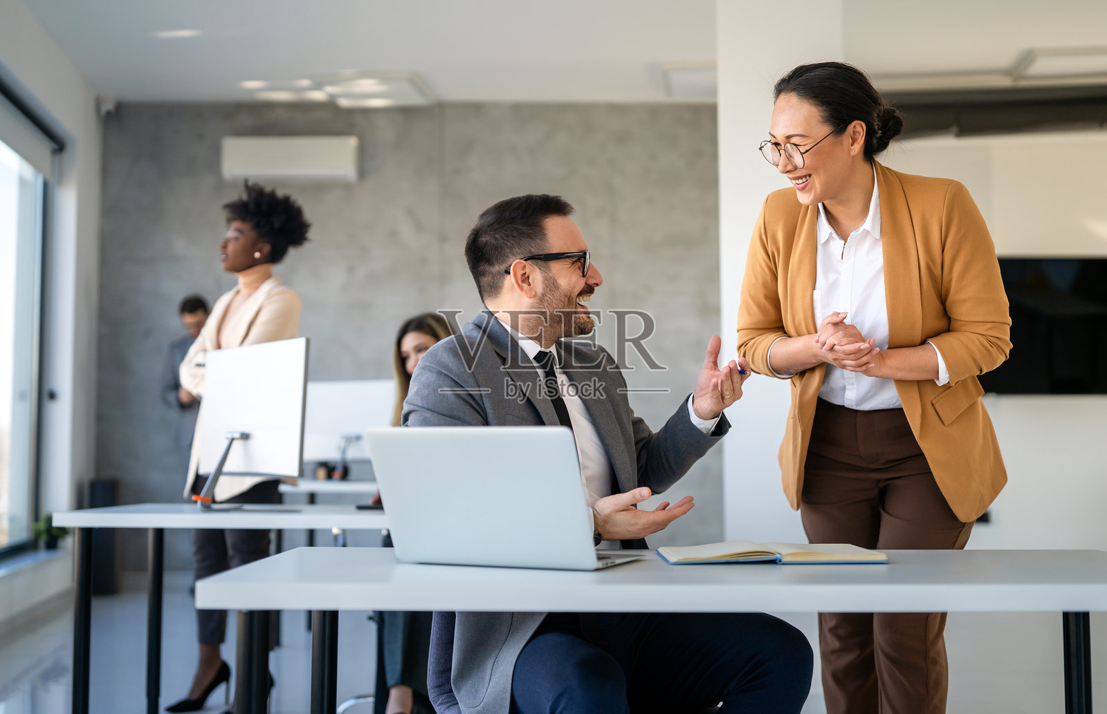 不同背景的创业公司员工在现代办公室里一起使用笔记本电脑工作照片摄影图片