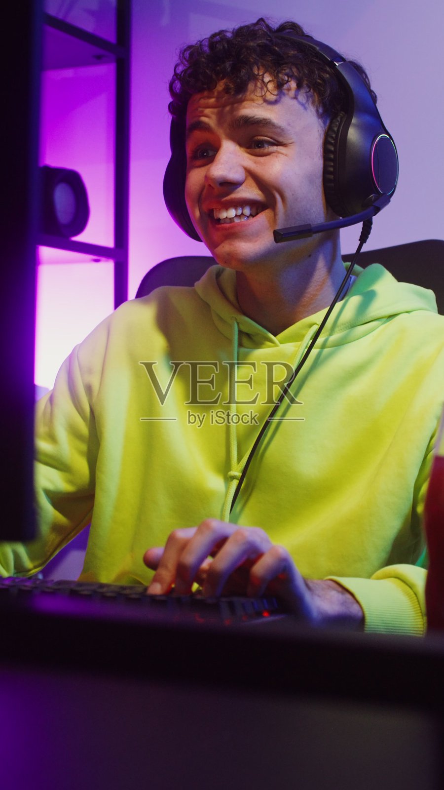 戴着耳机玩电子游戏的年轻人照片摄影图片